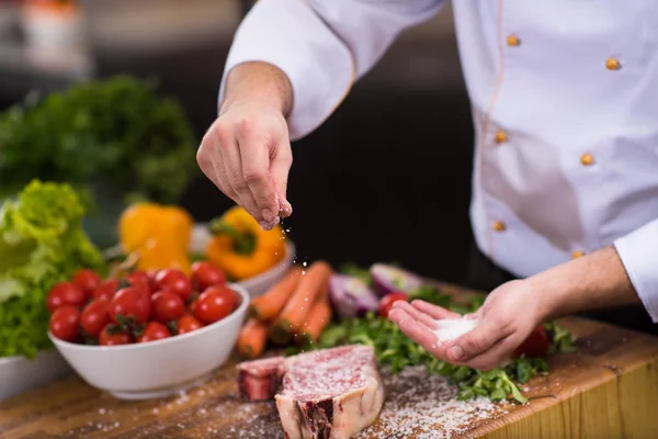 Mistr Kuchař Ruce Dávat Sůl Šťavnatý Plátek Syrové Steak Zeleninou Stock Fotografie