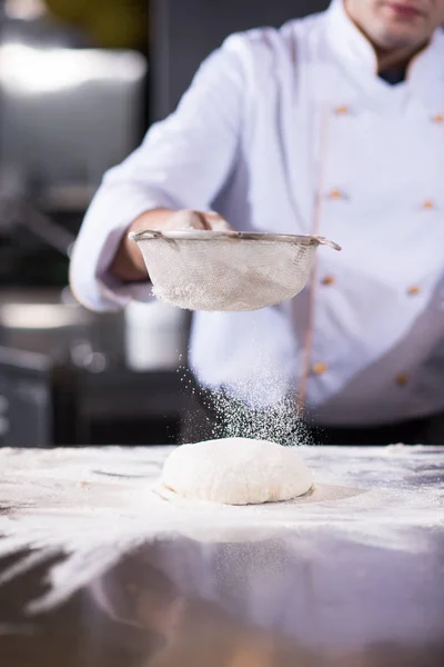 Chef Streut Mehl Über Frischen Pizzateig Auf Küchentisch — Stockfoto