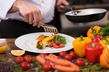 Şef lokanta mutfağında sebze salatası servis ediyor.