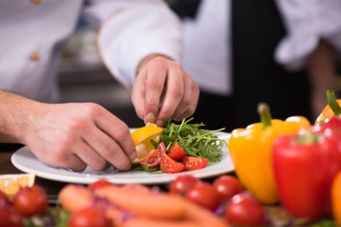 Şef lokanta mutfağında sebze salatası servis ediyor.