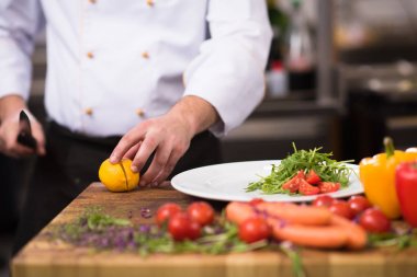 Şef lokanta mutfağında sebze salatası servis ediyor.