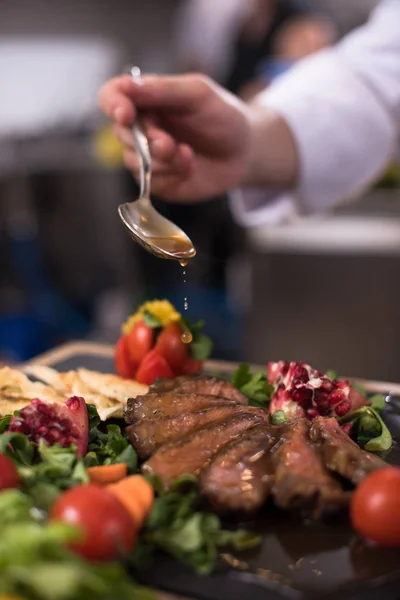 Szef kuchni rękę wykańczania płyty mięsa stek — Zdjęcie stockowe