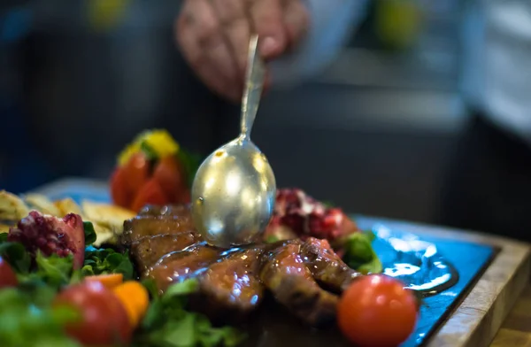 스테이크 고기 접시를 마무리 하는 요리사 손 — 스톡 사진