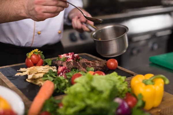 Chef mão acabamento prato de carne de bife — Fotografia de Stock