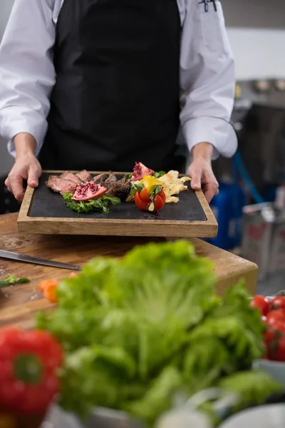 Female Chef holding beef steak plate — Stock Photo, Image