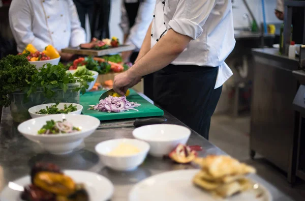 Equipo de cocineros y chefs preparando la comida —  Fotos de Stock