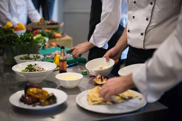 Equipo de cocineros y chefs preparando la comida —  Fotos de Stock