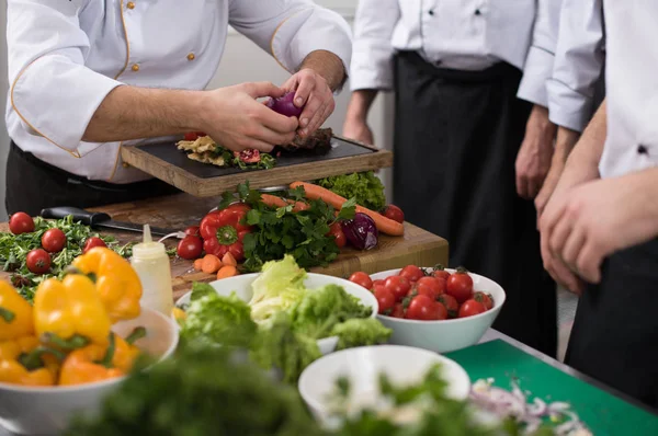 Cozinheiros de equipe e chefs preparando a refeição — Fotografia de Stock