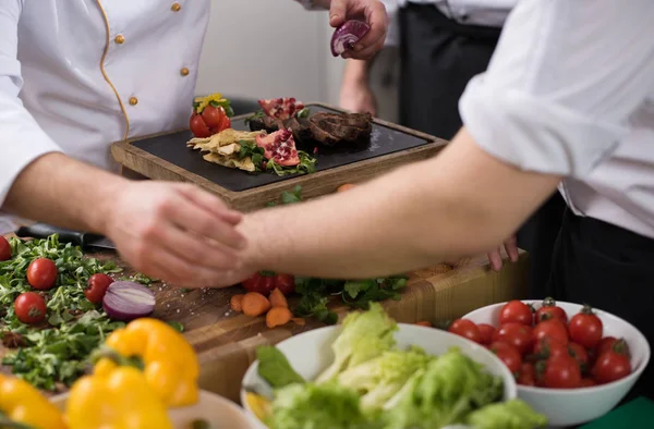 Equipo de cocineros y chefs preparando la comida —  Fotos de Stock