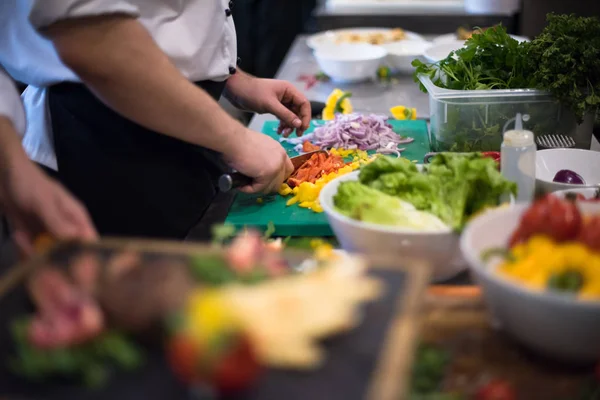 Kocken händer skära färska och läckra grönsaker — Stockfoto