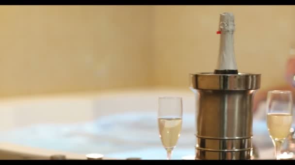 잘생긴 남자는 리조트 스파에서 촛불과 샴페인을 욕조에서 휴식을 즐긴다 — 비디오