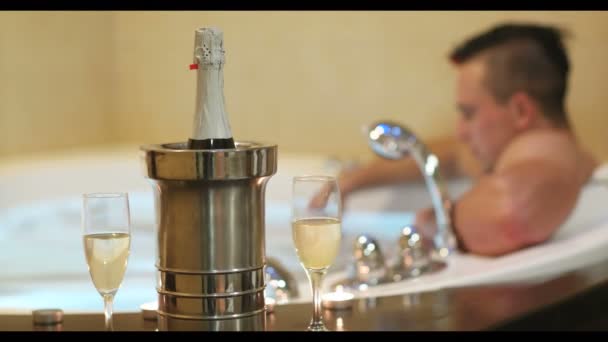 年轻英俊的男子喜欢在豪华度假胜地温泉里用蜡烛和香槟酒放松自己 — 图库视频影像