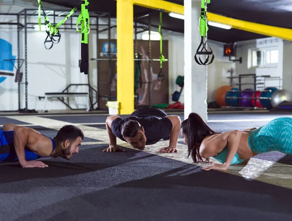 Grupo Jovens Saudáveis Fazendo Flexões Ginásio Crossfitness — Fotografia de Stock