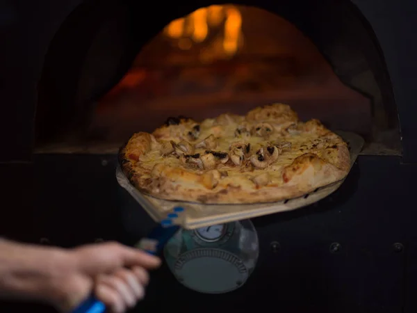 Chef removendo pizza quente do fogão — Fotografia de Stock