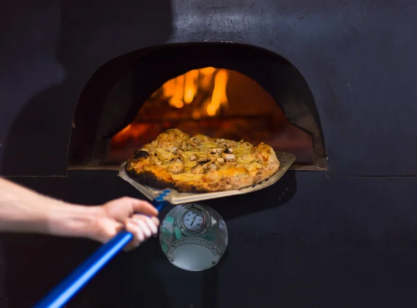 Chef removendo pizza quente do fogão — Fotografia de Stock