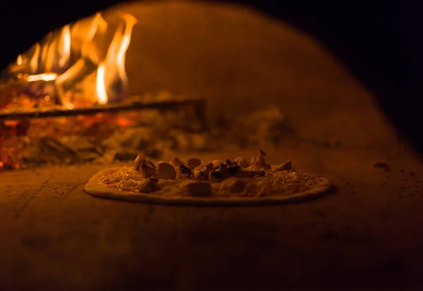 Chef putting delicious pizza to brick wood oven — Stock Photo, Image