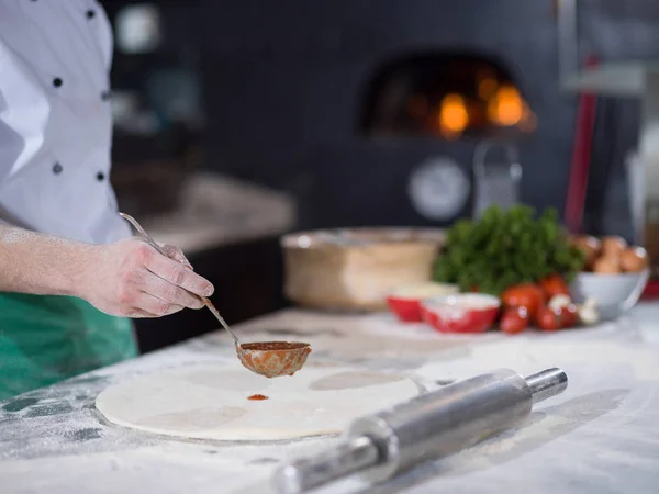 Kuchař, rozmazání těsto na pizzu s kečupem — Stock fotografie