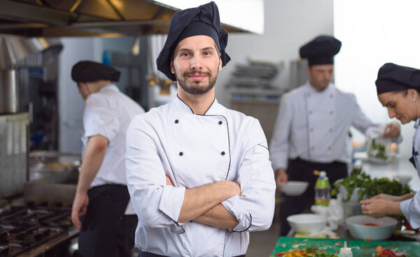 Portrait of young chef standing in commercial kitchen at restaurant