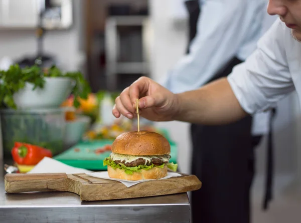 Chef finishing burger — Stock Photo, Image
