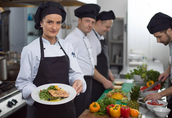 Şef Restoran Mutfağında Sebzeli Kızarmış Somon Balığı Filetosu Tutuyor — Stok fotoğraf