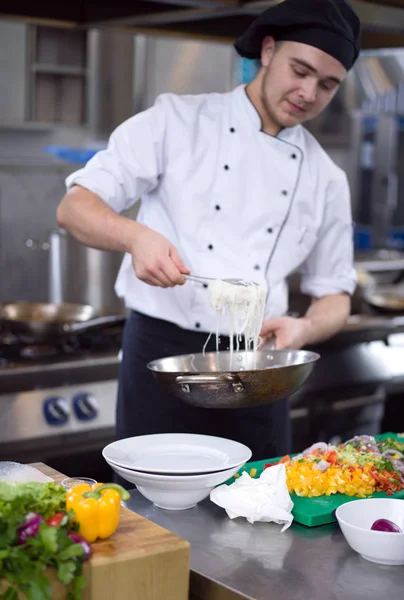 レストランキッチンでスパゲティを提供するシェフの手 — ストック写真
