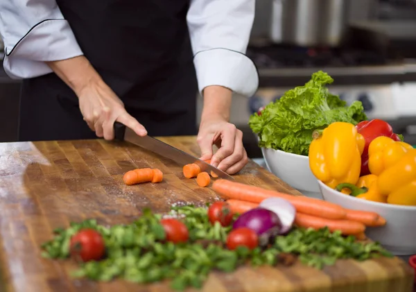 Руки шеф-повара режут морковь — стоковое фото
