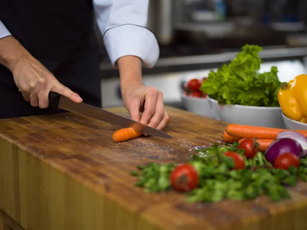 Chef hands cutting carrots — Stock Photo, Image