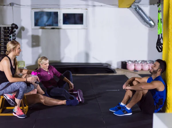 Grupo Jovens Atletas Sentados Chão Relaxantes Após Exercício Ginásio Crossfitness — Fotografia de Stock