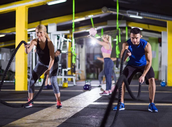 Sportowe para robi bitwy liny crossfitness ćwiczenie — Zdjęcie stockowe