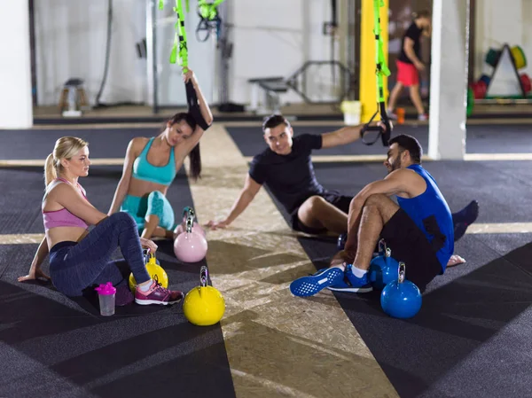 Grupo Jovens Atletas Sentados Chão Relaxantes Após Exercício Ginásio Crossfitness — Fotografia de Stock