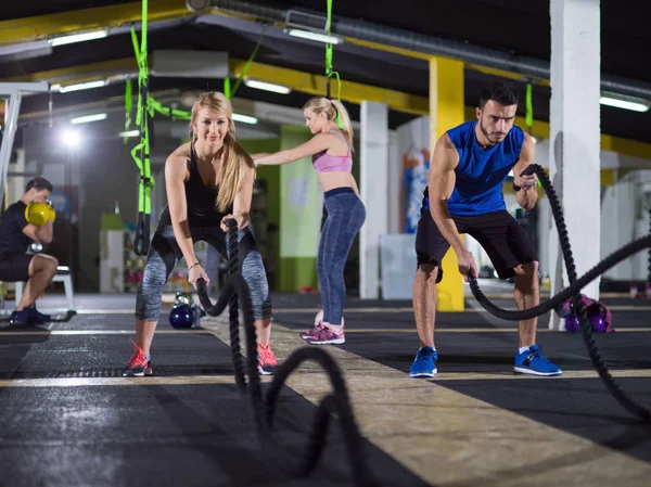 Sports couple doing battle ropes crossfitness exercise — Stock Photo, Image