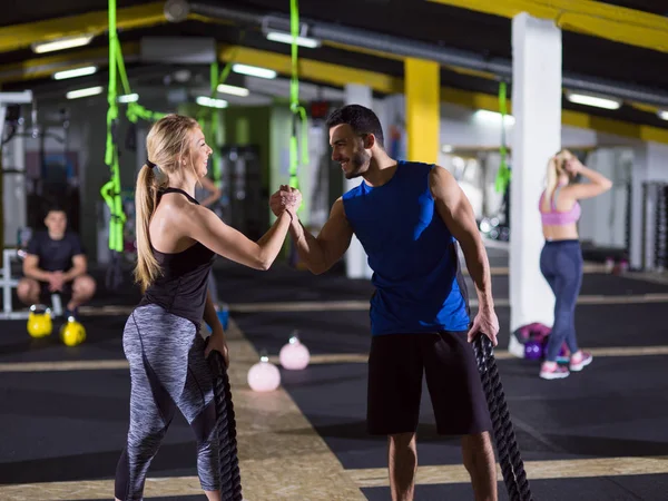 Deportes pareja haciendo batalla cuerdas crossfitness ejercicio —  Fotos de Stock