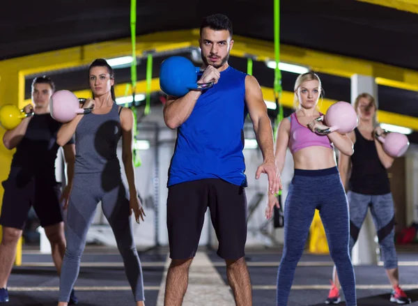 Athletes doing exercises with kettlebells — Stock Photo, Image