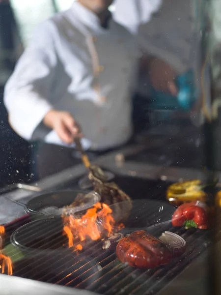 Chef cozinhar bife com legumes em um churrasco — Fotografia de Stock