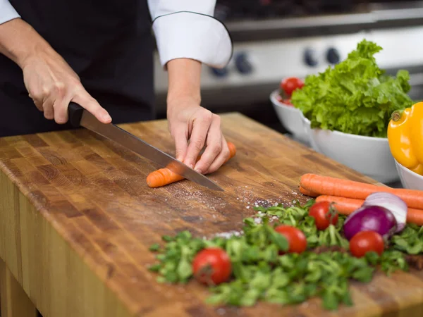 Chef hands cutting carrots — Stock Photo, Image
