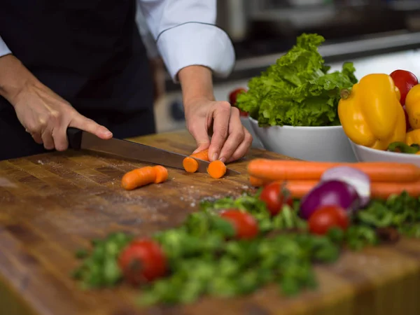 Кухарські руки, що ріжуть моркву — стокове фото