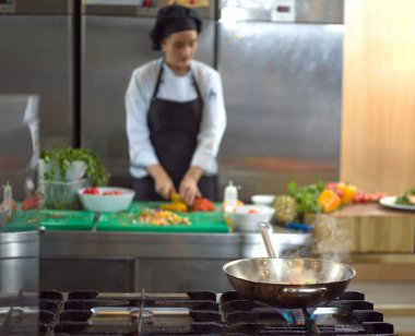 Aşçı taze ve lezzetli sebzeleri yemek veya salata için kesiyor.