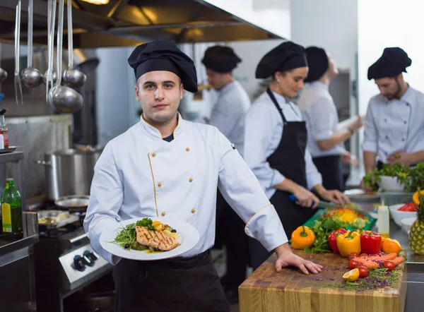 Şef Restoran Mutfağında Sebzeli Kızarmış Somon Balığı Filetosu Tutuyor — Stok fotoğraf