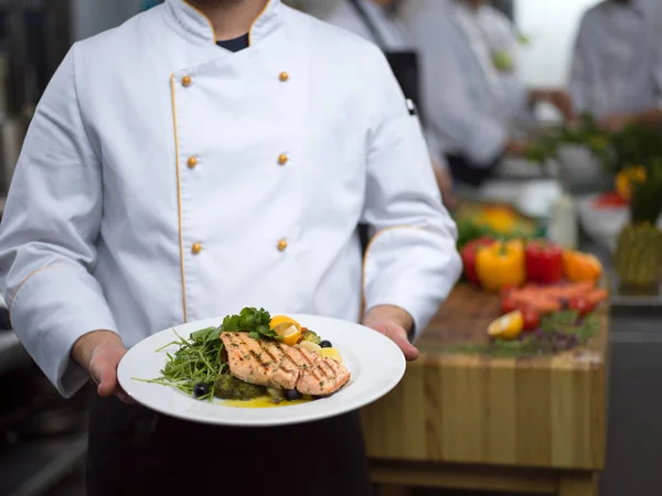 Chef holding dish of fried Salmon fish fillet — Stock Photo, Image