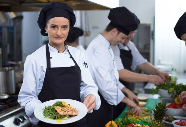 Şef Restoran Mutfağında Sebzeli Kızarmış Somon Balığı Filetosu Tutuyor — Stok fotoğraf