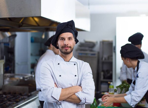 Portrait of young chef standing in commercial kitchen at restaurant