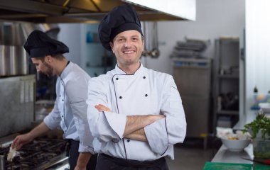 Restoranda ticari mutfakta duran genç aşçının portresi.