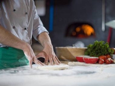 Şef pizza için hamur hazırlıyor.