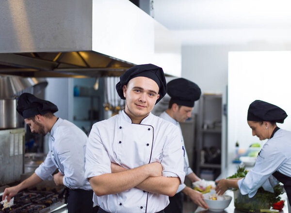 Portrait of young chef standing in commercial kitchen at restaurant