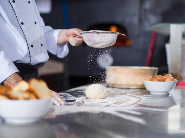 Chef streut Mehl über frischen Pizzateig — Stockfoto