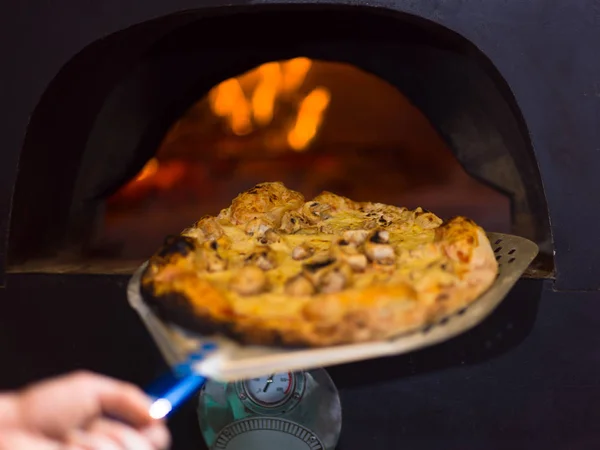 Koch entfernt heiße Pizza vom Herd — Stockfoto