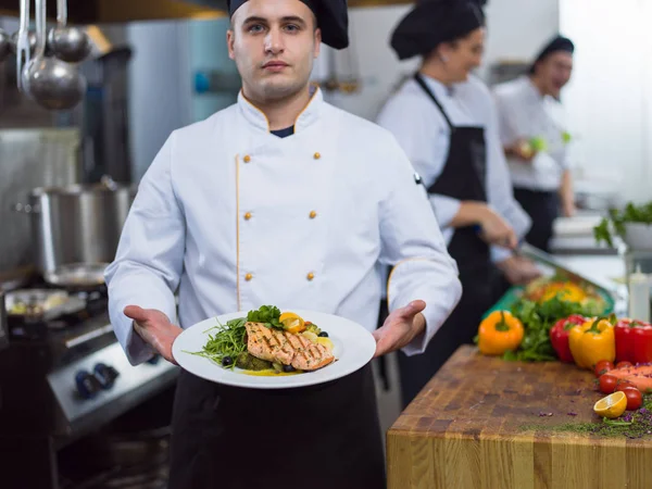 Şef Restoran Mutfağında Sebzeli Kızarmış Somon Balığı Filetosu Tutuyor — Stok fotoğraf