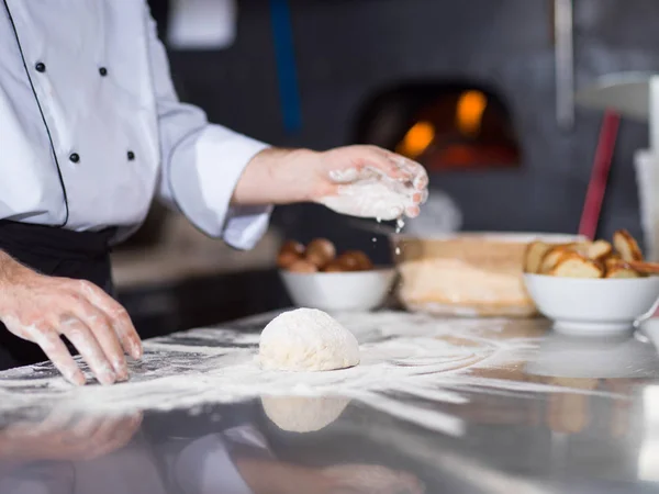 Chef Streut Mehl Über Frischen Pizzateig Auf Küchentisch — Stockfoto