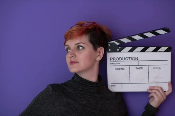 Redhead woman holding movie  clapper on purple background —  Fotos de Stock