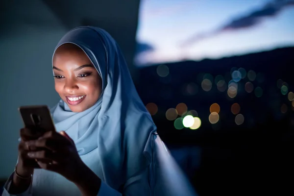Młoda muzułmanka w nocy na ulicy przez telefon. — Zdjęcie stockowe